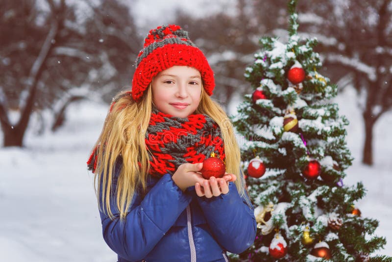 Adolescente bonito ou menina que decoram a árvore de Natal exterior foto de stock Adolescente bonito ou menina que decoram a árvore de Natal exterior foto de stock