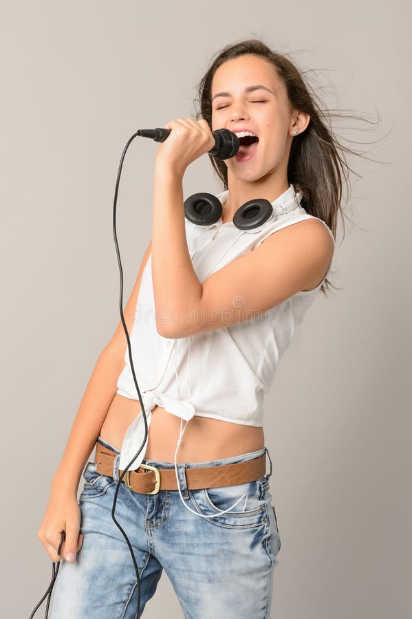 Adolescente cantante con los ojos cerrados micrófono imagenes de archivo Adolescente cantante con los ojos cerrados micrófono imagenes de archivo