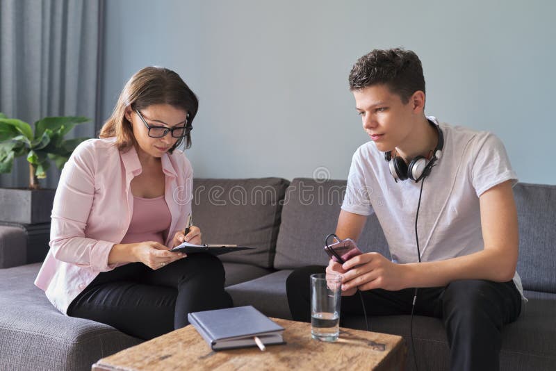 Teen boy talking to professional psychologist, individual therapy session for teenage with doctor. Difficulties of adolescence, mental health, social life of teenager. Teen boy talking to professional psychologist, individual therapy session for teenage with doctor. Difficulties of adolescence, mental health, social life of teenager