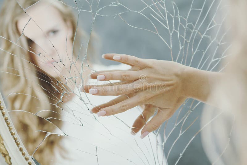 Teenage girl with depression holding her hand on the broken mirror. Teenage girl with depression holding her hand on the broken mirror