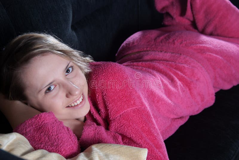 Adolescente con los pijamas en el sofá fotografía de archivo libre de regalías Adolescente con los pijamas en el sofá fotografía de archivo libre de regalías