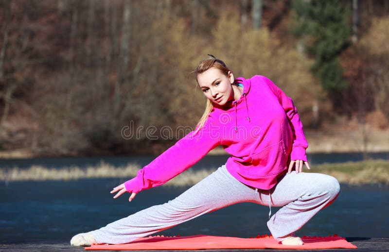 Adolescente da mulher no fato de esporte que faz o exercício no cais exterior imagem de stock Adolescente da mulher no fato de esporte que faz o exercício no cais exterior imagem de stock