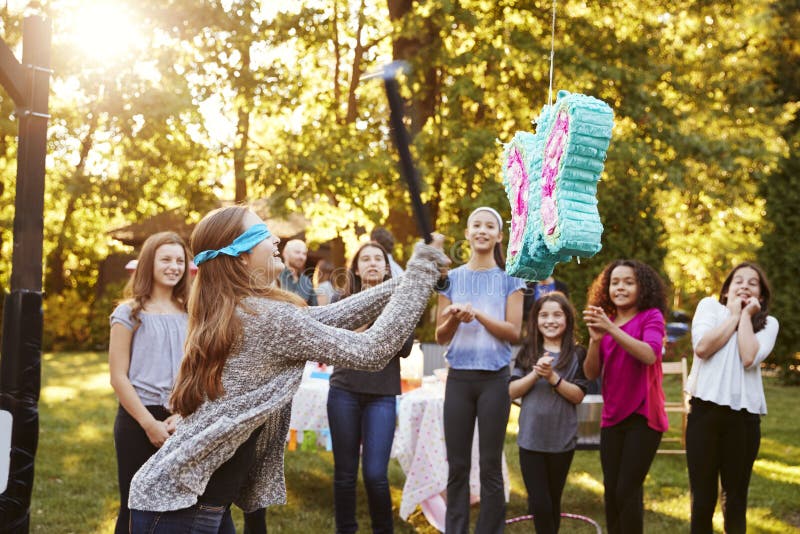 Adolescente de montre d'amis frappant un ata de ½ de ¿ de piï sur son anniversaire image libre de droits Adolescente de montre d'amis frappant un ata de ½ de ¿ de piï sur son anniversaire image libre de droits