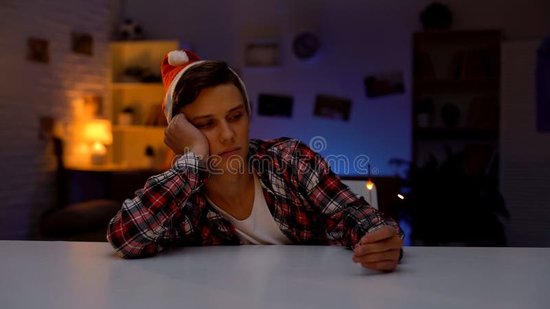 Adolescente deprimido solo en el sombrero de Pap? Noel que celebra el A?o Nuevo que lleva a cabo la luz de Bengala imágenes de archivo libres de regalías Adolescente deprimido solo en el sombrero de Pap? Noel que celebra el A?o Nuevo que lleva a cabo la luz de Bengala imágenes de archivo libres de regalías