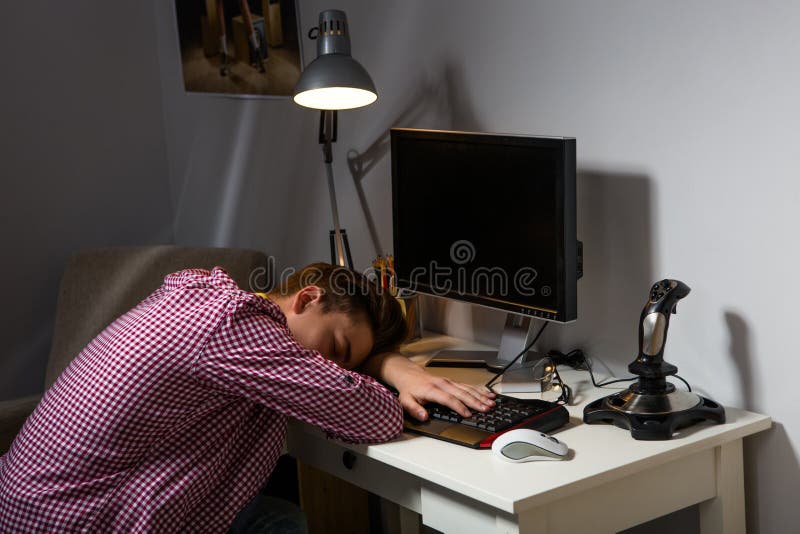 Teenage boy addicted to computer. Demotivative teenager falling asleep in front of computer. Teenage boy addicted to computer. Demotivative teenager falling asleep in front of computer.