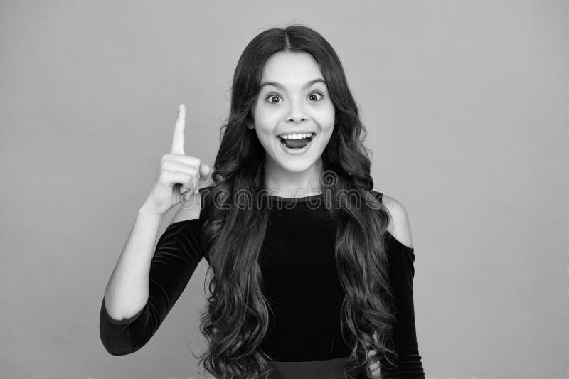 Adolescente eccitata. Ritratto di un adolescente carino con il dito in alto. La ragazza ha un'ottima nuova idea. Figlio riuscito. fotografia stock