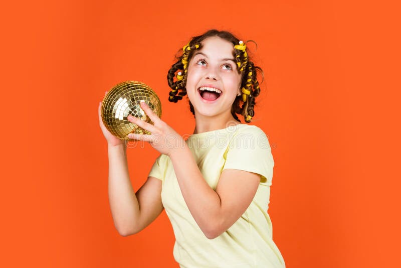 Adolescente elegante. peinado para discoteca party. divertirse. partido retro. niño sostener bola de disco de oro. chica alegre co imagen de archivo libre de regalías