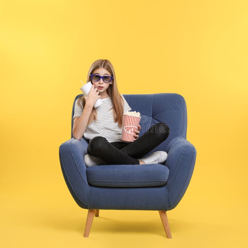 Adolescente emocional com os vidros 3D, a pipoca e a bebida sentando-se na poltrona durante a mostra do cinema imagens de stock Adolescente emocional com os vidros 3D, a pipoca e a bebida sentando-se na poltrona durante a mostra do cinema imagens de stock