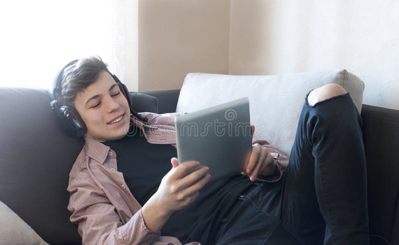 Adolescente en auriculares que escucha la música fotos de archivo Adolescente en auriculares que escucha la música fotos de archivo