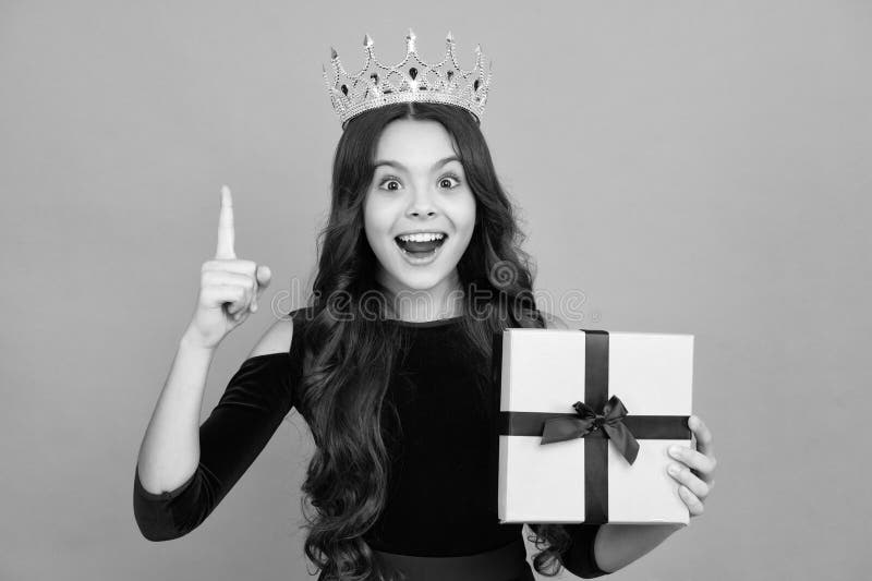 Adolescente entusiasta principessa della corona. adolescente con scatola presente. ragazza che fa un regalo di compleanno. present immagine stock