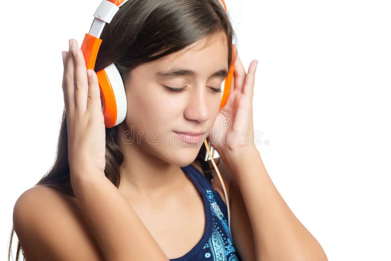 Adolescente hispánico hermoso que disfruta de música en los auriculares anaranjados brillantes foto de archivo libre de regalías Adolescente hispánico hermoso que disfruta de música en los auriculares anaranjados brillantes foto de archivo libre de regalías