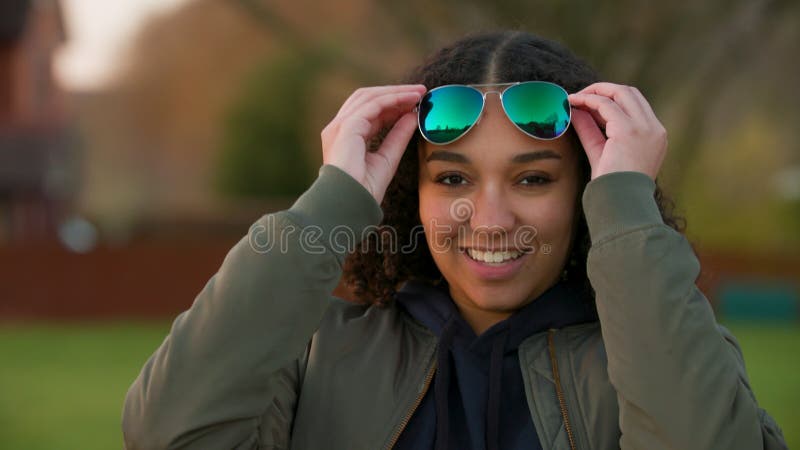 Adolescente mixte race africaine américaine jeune femme enlever des lunettes de soleil et les mettre sur sa tête clips vidéos