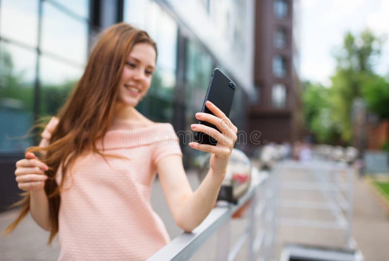 Adolescente que sorri ao tomar um tiro do selfie imagens de stock Adolescente que sorri ao tomar um tiro do selfie imagens de stock