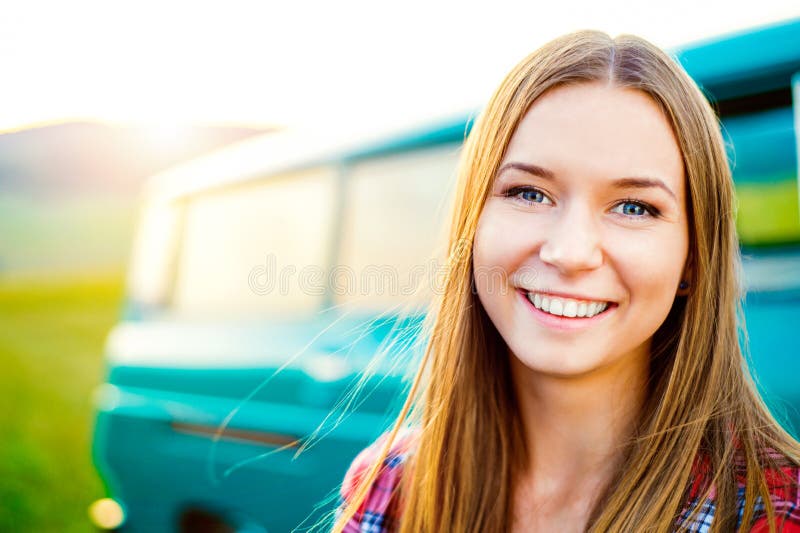 Adolescente que sorri contra a parte externa campervan verde na natureza foto de stock royalty free Adolescente que sorri contra a parte externa campervan verde na natureza foto de stock royalty free