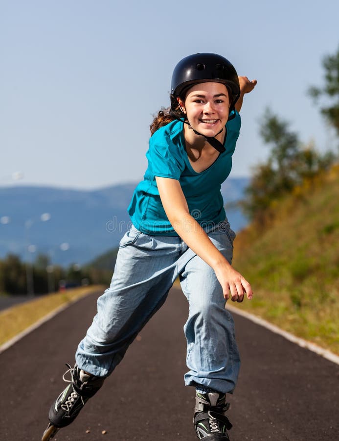 Une Fille D'âge Préscolaire Portant Un Casque De Protection Et Des Patins à  Roulettes Roule Sur Un Chemin D'asphalte