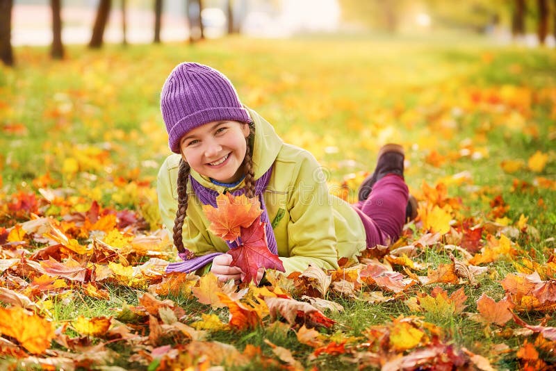 Adolescente sonriente que se relaja en amarillo del parque del otoño amarillo retrato del otoño del bebé en hoja de arce fotos de archivo Adolescente sonriente que se relaja en amarillo del parque del otoño amarillo retrato del otoño del bebé en hoja de arce fotos de archivo