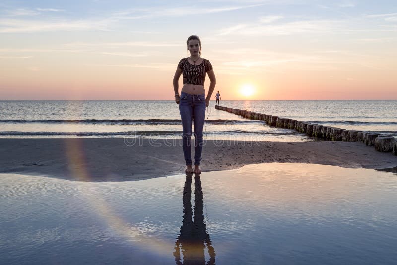 Adolescente sulla spiaggia al tramonto fotografie stock libere da diritti