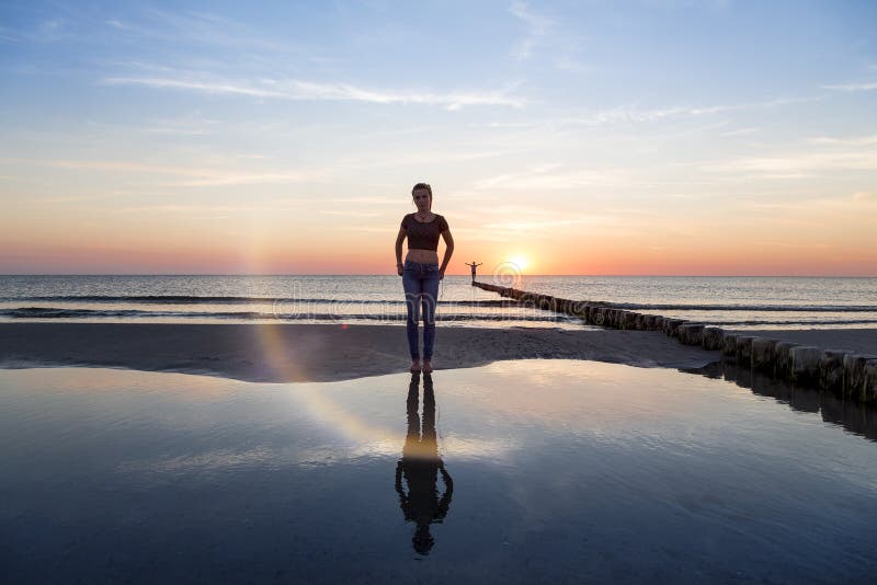 Ragazza adolescente sulla spiaggia al tramonto fotografie stock