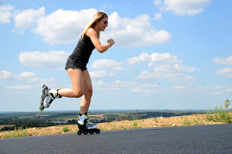Adolescente sur des patins de rouleau à l'été images stock Adolescente sur des patins de rouleau à l'été images stock