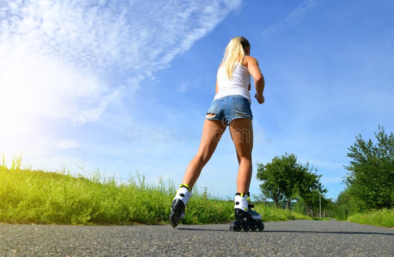 Adolescente sur des patins de rouleau à l'été photo libre de droits Adolescente sur des patins de rouleau à l'été photo libre de droits