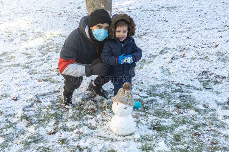 Adolescente Y Niño Pequeño Con Guantes Y Botas De Abrigo De Nieve En Un Día  De Invierno Imagen de archivo - Imagen de entusiasmo, snowman: 207109795