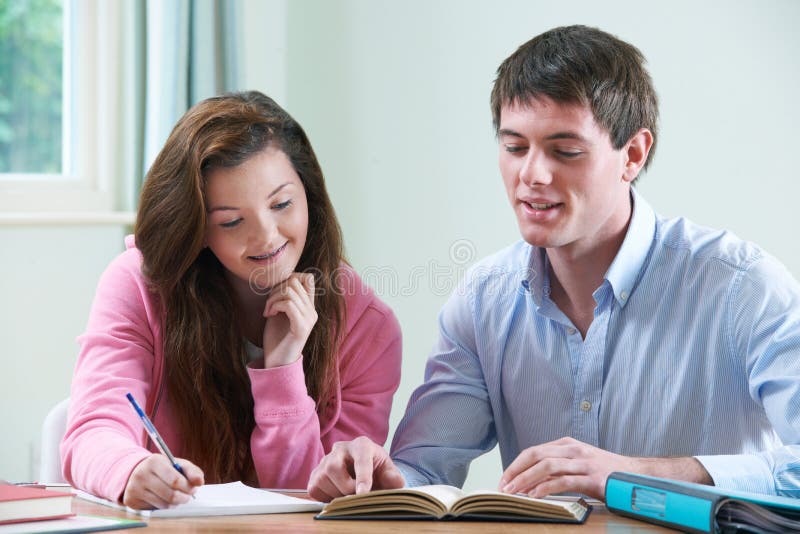Adolescente étudiant avec le tuteur à la maison images stock