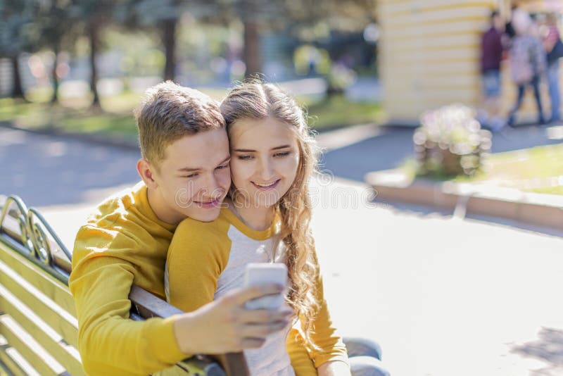 Adolescentes dos pares em um banco foto de stock Adolescentes dos pares em um banco foto de stock