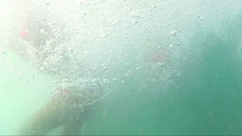 Adolescentes felices que saltan de la nave al mar y que miran la cámara, outoors