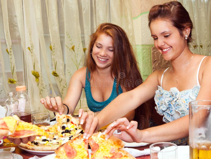 Adolescentes que comen la pizza en restaurante fotografía de archivo libre de regalías Adolescentes que comen la pizza en restaurante fotografía de archivo libre de regalías