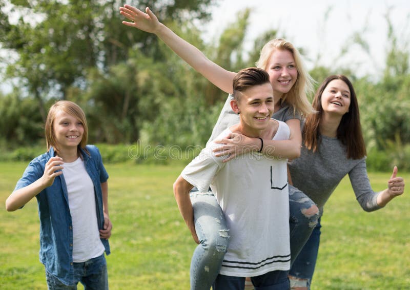 Adolescentes que corren a través de césped verde en verano en parque imagen de archivo Adolescentes que corren a través de césped verde en verano en parque imagen de archivo