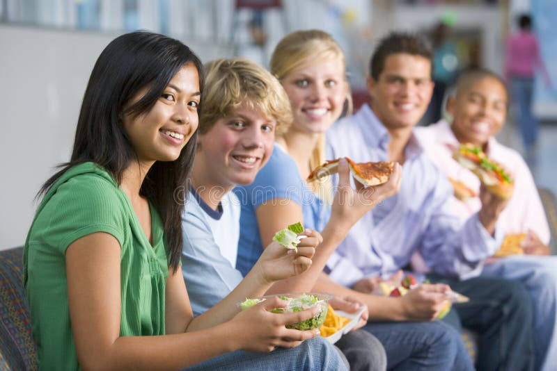 Adolescenti che godono insieme del pranzo fotografia stock