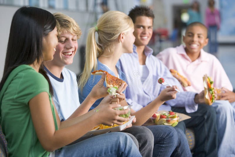 Adolescenti che godono insieme del pranzo immagini stock