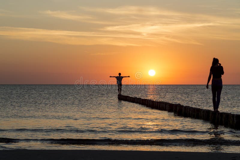 Due adolescenti che si equilibrano su uno sperone roccioso immagine stock