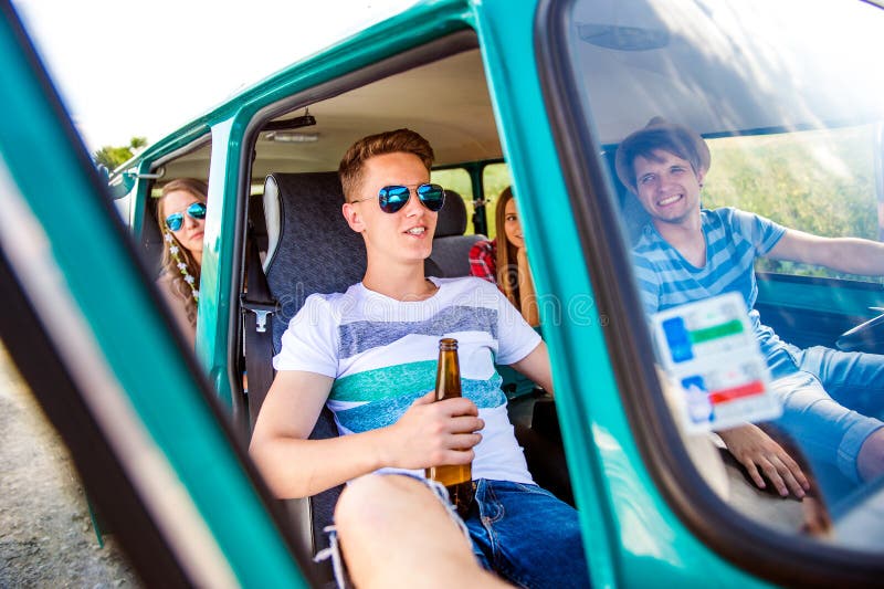 Adolescents à l'intérieur d'une vieille bière campervan et potable, promenade en voiture photographie stock libre de droits Adolescents à l'intérieur d'une vieille bière campervan et potable, promenade en voiture photographie stock libre de droits