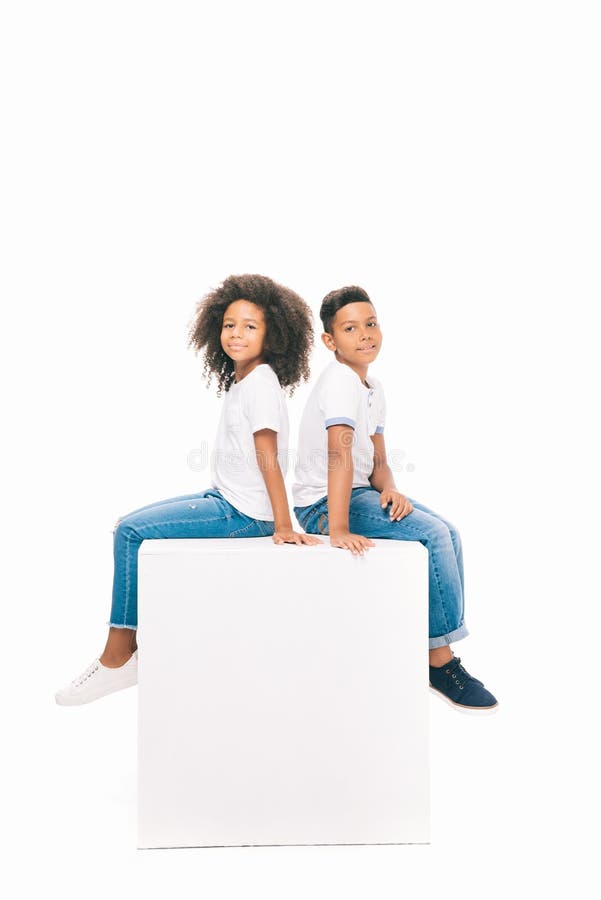 adorable african american kids sitting together and smiling at camera isolated on white