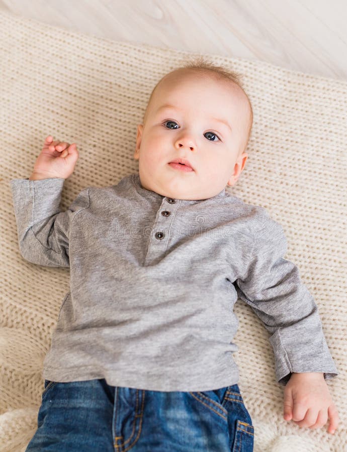 Adorable Baby Boy in Beige Sunny Bedroom. Newborn Child Relaxing ...