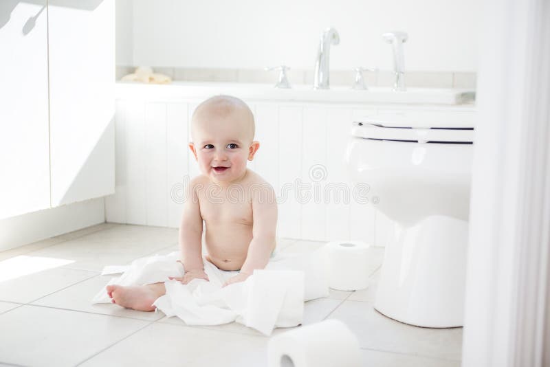 Adorable baby boy playing with toilet paper