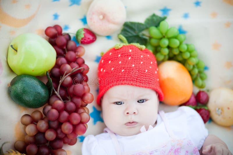 Adorable baby girl in the fruits