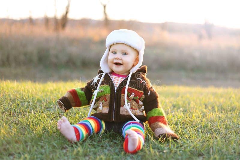 Adorable Baby Girl in Winter Hat and Sweater Laughing Outside royalty free stock photo Adorable Baby Girl in Winter Hat and Sweater Laughing Outside royalty free stock photo