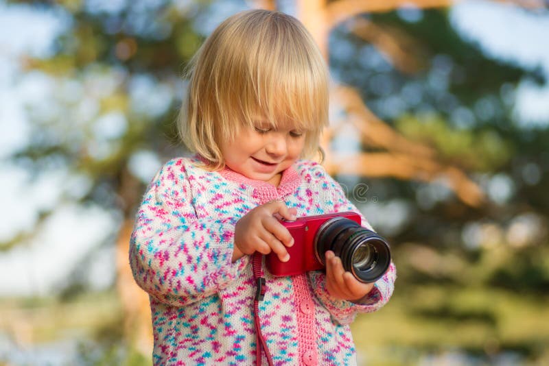 Adorable baby shoot compact camera in park