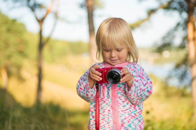 Adorable baby shoot compact camera in park