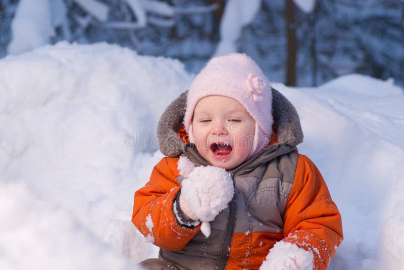 Adorable baby try to eat cold snow