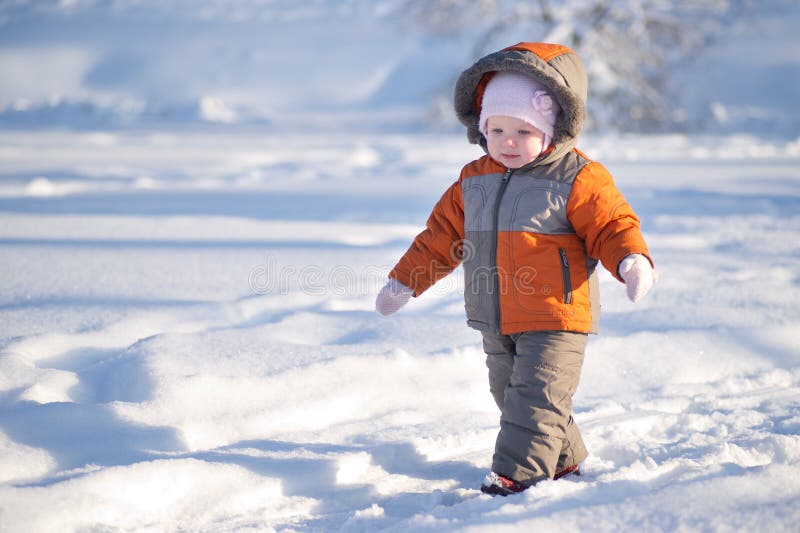 Adorable baby walk by lakes ice in park