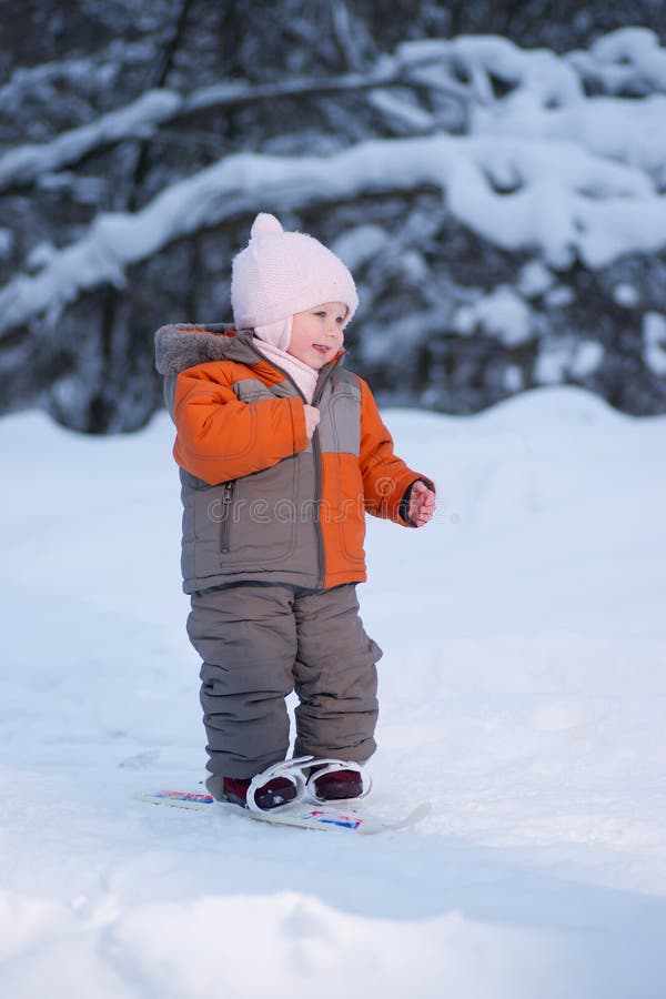 Adorable baby walk on ski in park