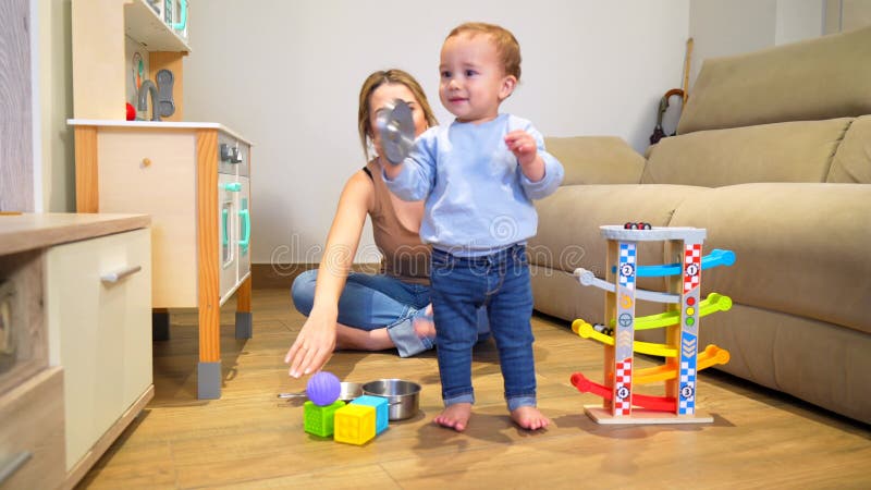 Adorable bebé jugando con juguetes y madre en casa metrajes