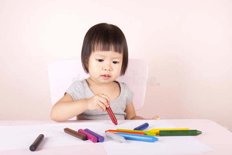 Adorable child drawing with colorful crayons. royalty free stock photography