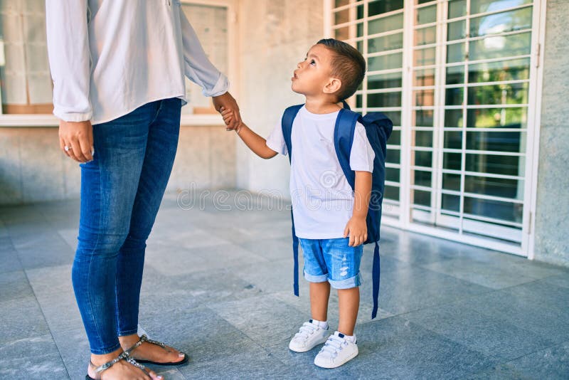 Adorable estudiante latino y mamá esperando en la escuela foto de archivo libre de regalías