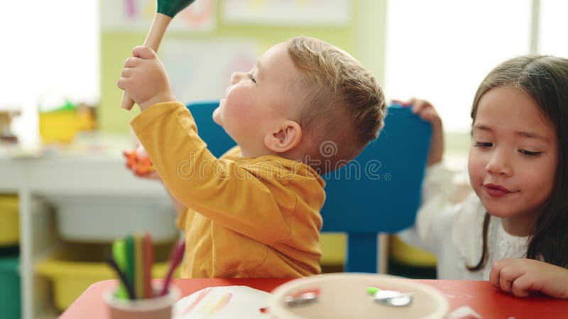 Adorable garçon et fille jouant de la suce maraca à la maternelle