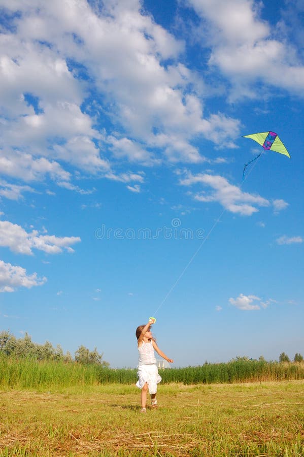 Adorable girl flying a kite