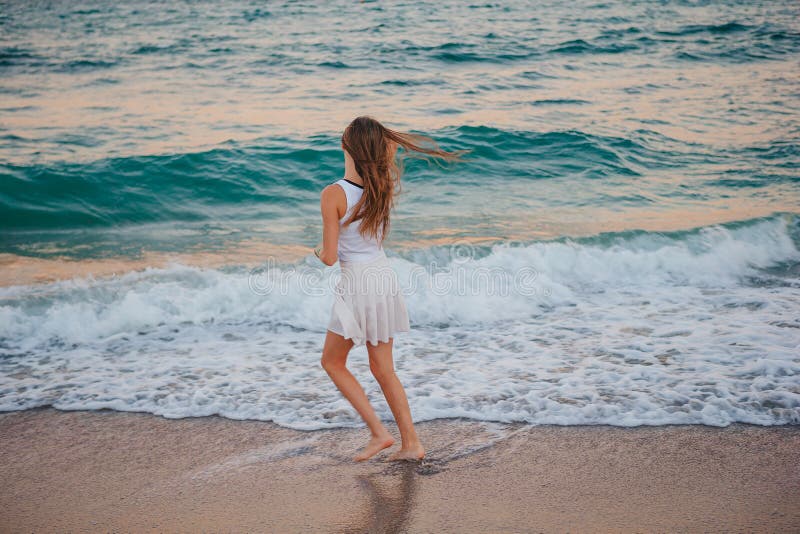 Adorable Girl Have Fun on the Beach is Shallow Water at Sunset Stock ...